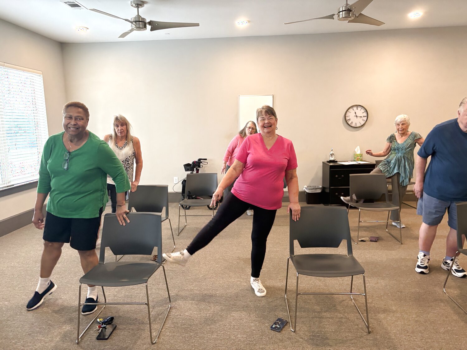 Residents practicing standing functional movement with chair support